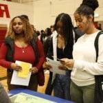 Students read and listen to more information at a booth at the Black College Expo